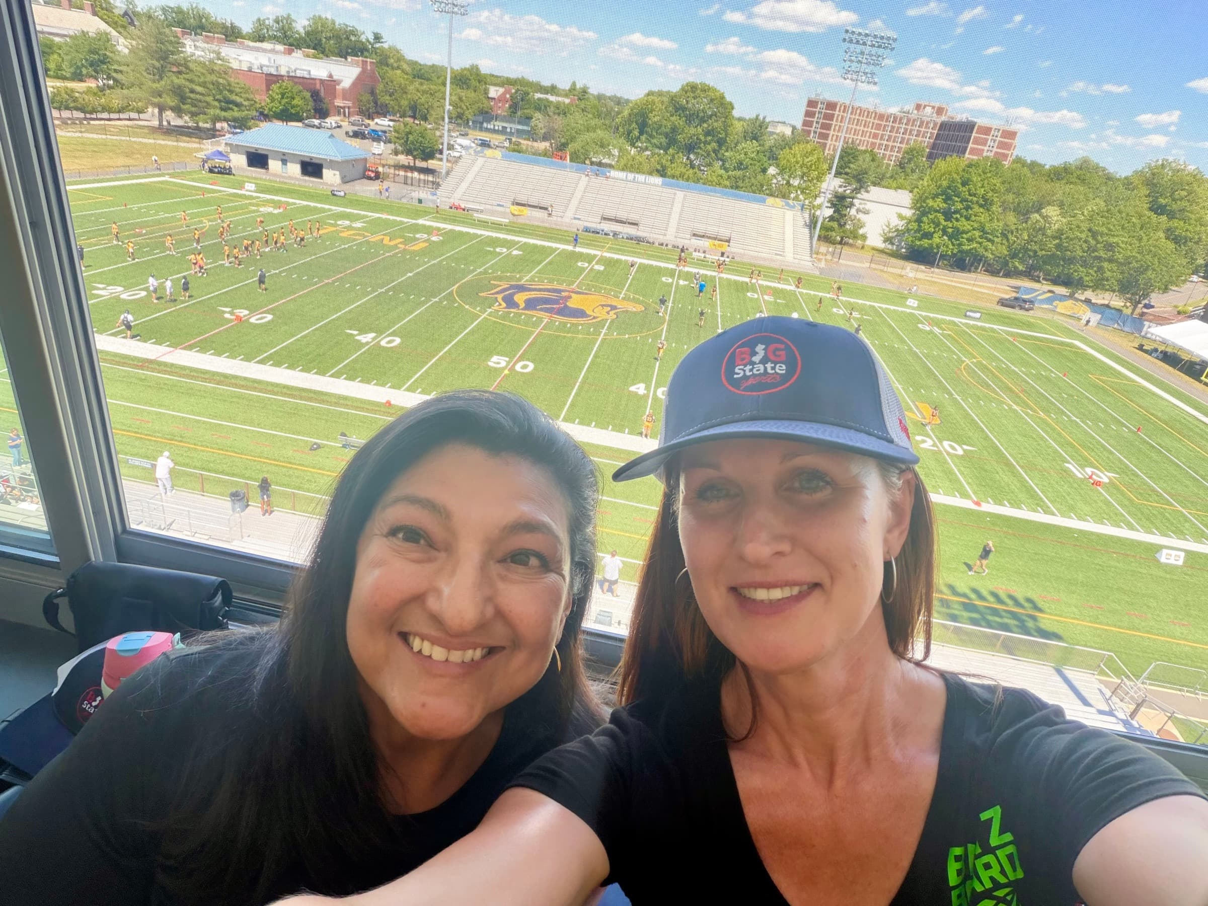 Teri Brooks and Janice Grimsley in the press box above a flag football field