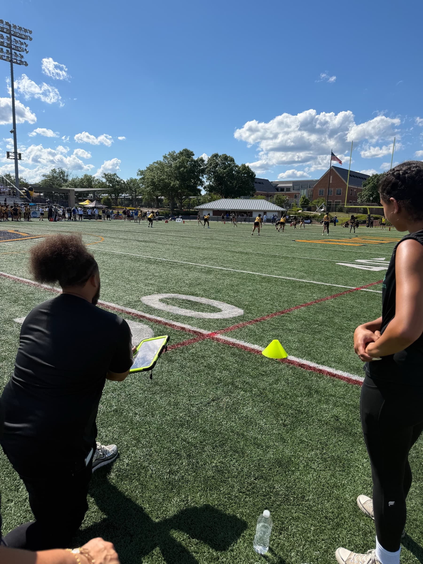 Coach kneeling on the sideline during a game